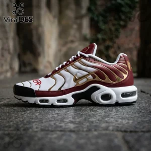 Nike Air Max Plus sneaker in maroon, white, and gold with a mesh upper, black rubber toe cap, and visible air sole units.!