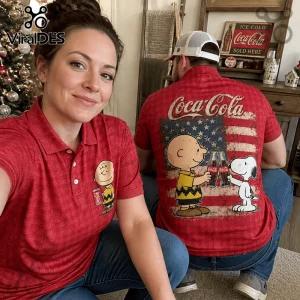 Red polo shirt featuring Charlie Brown and Snoopy drinking Coca-Cola in front of a distressed American flag graphic.!