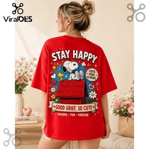 Red graphic t-shirt featuring Snoopy on a red doghouse with Woodstock, text reading Stay Happy and Good Grief, So Cute.!