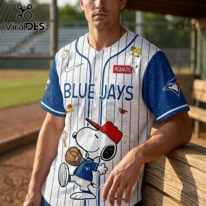 Toronto Blue Jays baseball jersey featuring Peanuts Snoopy character graphics, blue pinstripes, and white fabric base.!
