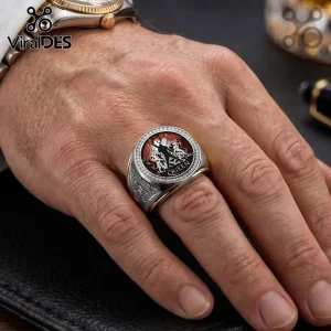 Silver Queen band ring featuring the crest logo with red accents on a male finger against a dark background.!