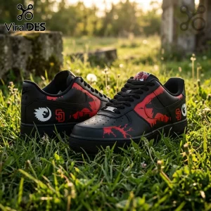 Custom black and red sneakers with dinosaur silhouettes and SD logos sitting in green grass.!