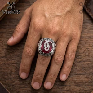 Oklahoma Sooners 2026 championship ring featuring a large red gemstone with a white OU logo surrounded by small crystals.!