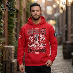 Man wearing red Carolina Hurricanes Stanley Cup 2026 champions hoodie with graphic print in an outdoor alleyway.!