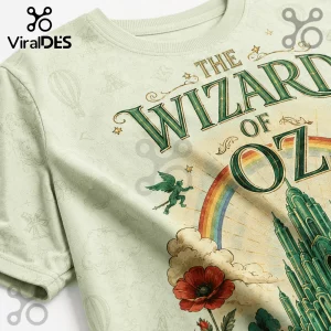 Light green graphic t-shirt featuring The Wizard of Oz text, Emerald City, rainbow, poppy flower, and flying monkey art.!