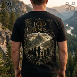 Black cotton t-shirt featuring The Lord of the Rings gold foil graphic of the Fellowship walking toward a mountain range.!