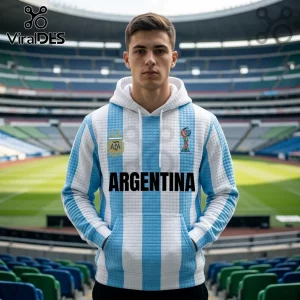 Man wearing a white and light blue Argentina soccer jersey hoodie with AFA emblem and textured fabric in a stadium.!