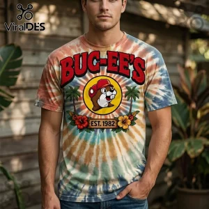 Tie-dye t-shirt featuring a Buc-ee's beaver logo, palm trees, hibiscus flowers, and EST. 1982 text on a cotton crew neck.!