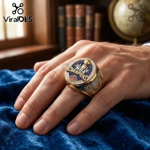 Gold NBA 2026 Champions ring with blue enamel, New York Knicks logo, and diamond-encrusted bezel on a hand.!