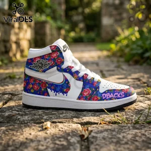 Air Jordan high-top sneaker with white leather, blue floral pattern, and the word DBACKS in pink on the toe box.!