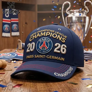 Navy blue Paris Saint-Germain baseball cap with gold 2026 Champions embroidery and club logo on a wooden table surface.!