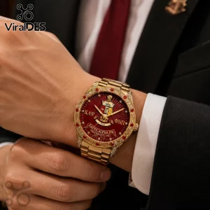 Gold-tone Kappa Alpha Psi watch with red dial, Greek letters, crest, and crystal-accented bezel on a person's wrist.!