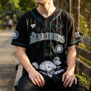Black Seattle Mariners baseball jersey featuring a KAWS-style character graphic on the front and team logo patches.!