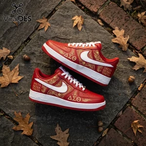 Custom red Nike Air Force 1 sneakers with gold Delta Sigma Theta Greek letters and ornate floral detailing on stone floor.!