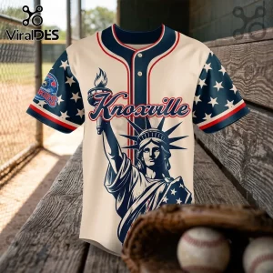Knoxville baseball jersey with Statue of Liberty graphic, blue star sleeves, and red trim on a wooden bench.!