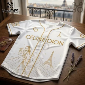 White baseball jersey with gold Celine Dion text, Eiffel Tower illustration, singer graphic, and Paris 26 sleeve print.!