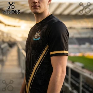Man wearing a black Newcastle United soccer jersey with gold trim and a prominent club crest in a stadium background.!