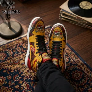 Custom high-top sneakers with Guns N' Roses theme, featuring red roses, gold accents, and black laces on a patterned rug.!