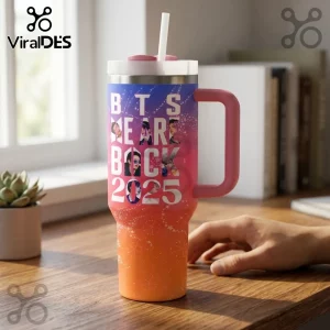 BTS 2025 Festa Stainless Steel Handle Tumbler with pink handle, white straw, and orange-to-blue gradient design on desk.