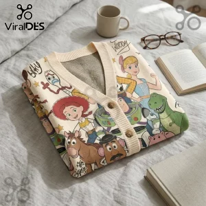 Cream knit cardigan featuring Toy Story character print of Woody, Buzz Lightyear, Jessie, Forky, and Rex on a grey bed.!