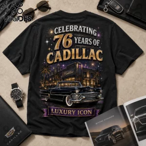 Black cotton t-shirt featuring a 76 years of Cadillac graphic with a classic car, city skyline, fireworks, and gold text.!