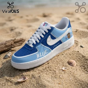 Custom blue and light blue leather low-top sneaker with white swoosh, white laces, and printed Champion branding on sand.!