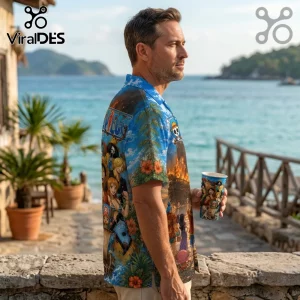 Man wearing a blue One Piece anime patterned button-up shirt while holding a matching printed paper cup by the ocean.!