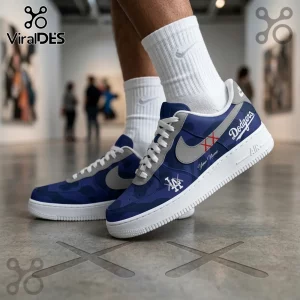 Los Angeles Dodgers x Kaws Air Force 1 sneakers featuring blue camo, grey swoosh, Dodgers branding, and white soles.