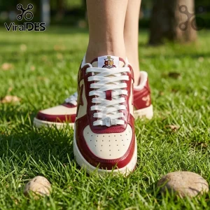 Maroon and cream patent leather sneaker with Alpha Kappa Alpha crest on tongue and white laces on green grass background.!