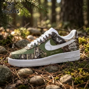 Custom olive and camouflage sneaker with white swoosh, moth graphic, and The Great Divide Tour 26 text on forest floor.!