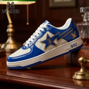 Blue and white patent leather sneaker featuring a gold-outlined star, dove emblem, and Greek letters ΦΒΣ on a wooden desk.!