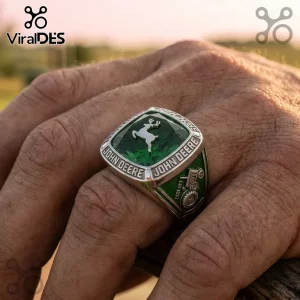 Silver John Deere class ring with a large emerald green stone, silver deer logo, and tractor side engraving.!