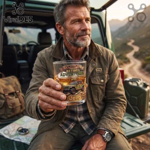 Man holding a whiskey glass with Retired Adventurer and Jeep graphics, seated in an off-road vehicle at sunset.!