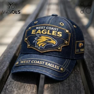 West Coast Eagles denim baseball cap with gold embroidery, metal rivets, and Est. 1986 side patch on a wooden bench.!