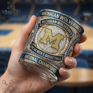 Michigan Wolverines NCAA basketball tumbler with blue and gold M logo and crystal embellishments on a glass surface.!