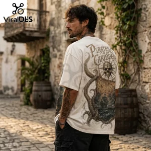 Man wearing cream t-shirt with Pirates of the Caribbean skull, octopus, and ship graphic on back in a stone street.!