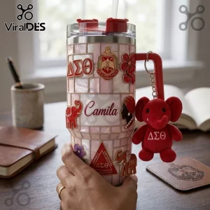 Pink tiled stainless steel tumbler featuring Delta Sigma Theta Greek letters, a plush red elephant keychain, and name.!