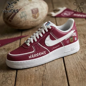 Maroon and white leather sneaker featuring Maroons and Champions text, a rugby ball, and a pennant on wood background.!