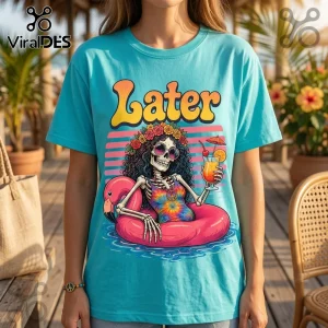 Turquoise crew neck t-shirt featuring a skeleton in a tie-dye swimsuit and sunglasses relaxing on a pink flamingo float.!