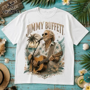 White t-shirt featuring a Jimmy Buffett graphic with palm trees, acoustic guitar, microphone, and tropical floral accents.!
