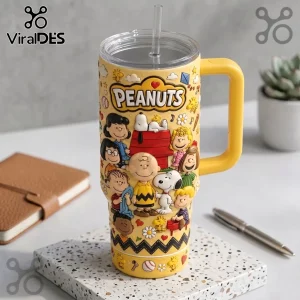 Yellow Peanuts tumbler with 3D embossed characters, handle, and clear straw on a terrazzo coaster.!