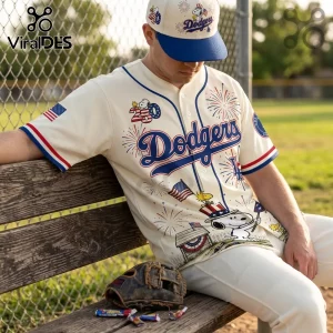 Man wearing cream-colored LA Dodgers Snoopy baseball jersey with red, white, and blue patriotic firework graphics.!
