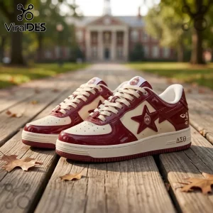 Maroon and cream patent leather sneakers with Delta Sigma Theta Greek letters and star logo on a wooden walkway.!