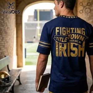 Man wearing a navy blue football jersey with gold Fighting Title Town Green Bay WI Irish text and shamrock collar accents.!