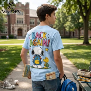 Light blue t-shirt with Peanuts characters Snoopy and Woodstock, colorful BACK AGAIN! text, worn by a student on campus.!