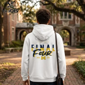 White hoodie with NCAA Men Final Four 2026 and Michigan M logo in blue and gold on back, worn by person on campus.!
