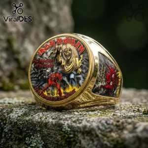 Gold Iron Maiden The Number of the Beast commemorative ring with Eddie the mascot and red demon art on a stone surface.!