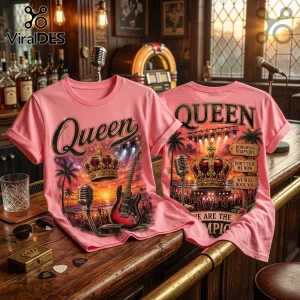 Pink cotton t-shirt featuring Queen band logo, crown graphic, electric guitar, and song titles on a wooden bar backdrop.!