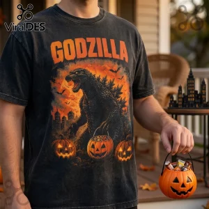 Godzilla Halloween 2026 Horror Theme T-Shirt featuring a monster with jack-o'-lantern buckets on a black cotton tee.