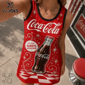 Woman wearing a sleeveless red tank dress featuring a Coca-Cola logo, glass bottle graphic, and star patterns.!